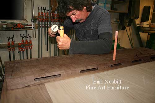 Earl pegging tenons at one end of a custom made dining table showing mortises
